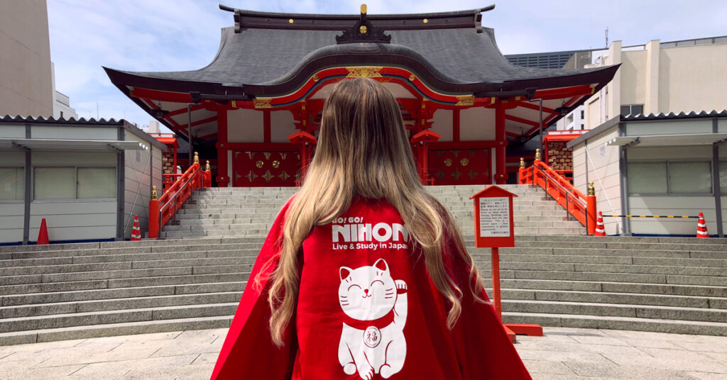 girl wearing Go Go Nihon shirt in front of a temple