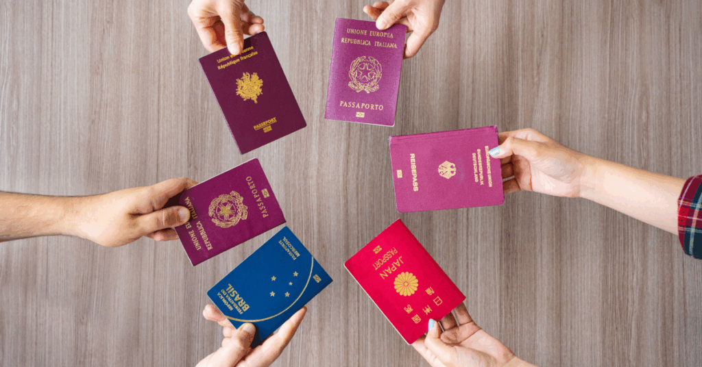 hands holding 5 different passports