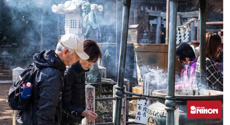 couple lighting incense at a shrine