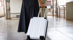person pulling white suitcase